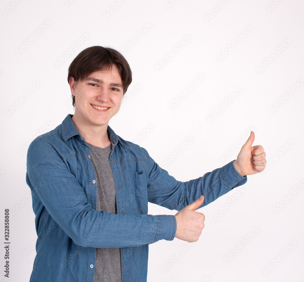 Young happy man with thumbs up sign in casuals isolated on white background.