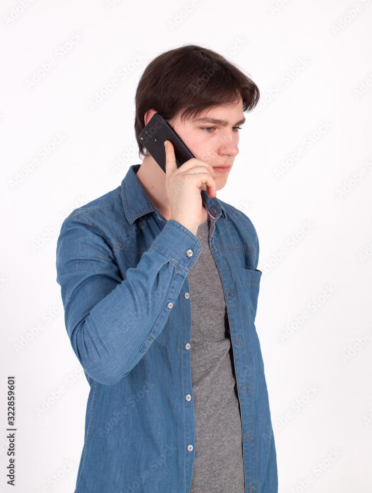 Young smiling man talking on the mobile phone and looking away. Isolated on white. Young smiling man talking on the mobile phone and looking away. Isolated on white.