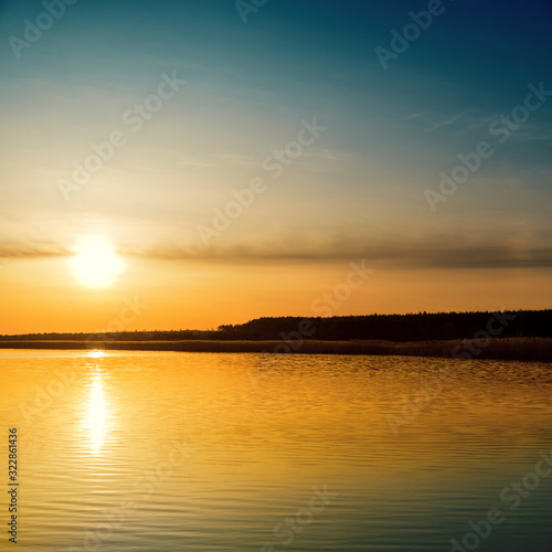 orange sunset in clouds over river