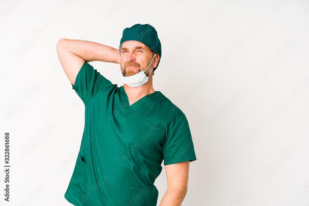 Surgeon senior man isolated on white background touching back of head, thinking and making a choice. Surgeon senior man isolated on white background touching back of head, thinking and making a choice.