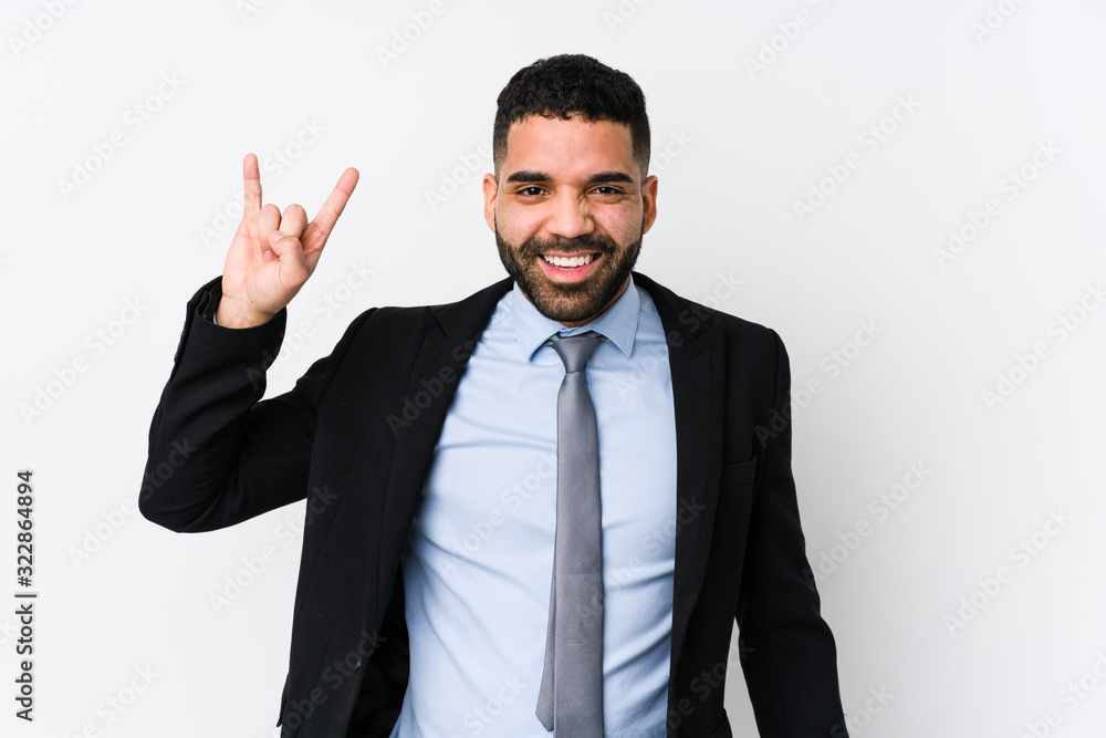 Young latin business woman against a white background isolated showing a horns gesture as a revolution concept. Young latin business woman against a white background isolated showing a horns gesture as a revolution concept.