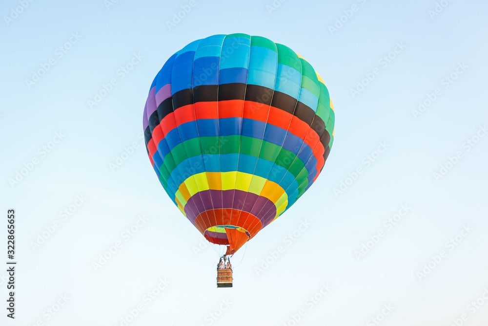 Obraz premium Hot air balloon over the field with blue sky