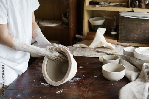 Female hands hold a bowl for casting clay products. Shaped method for making clay dishes. Handwork. Pottery making