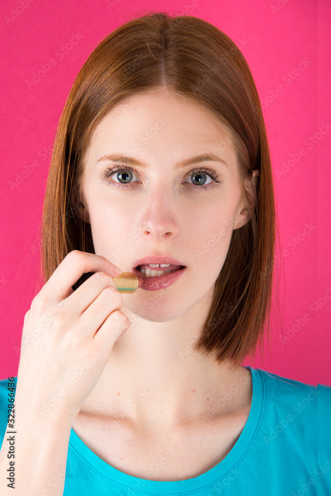 Pretty young woman applying nude color lipstick. Model with blue eyes and natural red hair and light skin with freckles Pretty young woman applying nude color lipstick. Model with blue eyes and natural red hair and light skin with freckles
