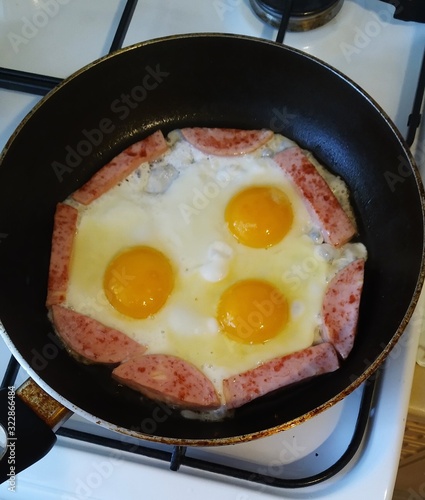  fried eggs with sausage lie in a pan