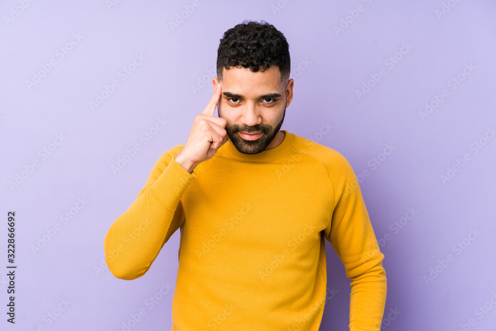 Young mixed race arabic man isolated pointing temple with finger, thinking, focused on a task. Young mixed race arabic man isolated pointing temple with finger, thinking, focused on a task.