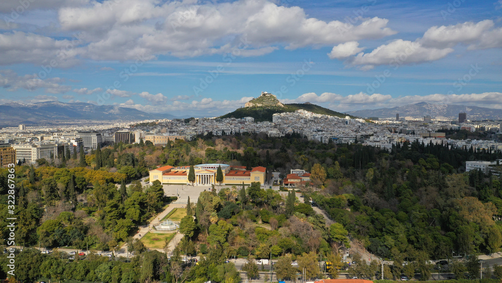 Aerial drone photo of renovated public neoclassic building of Zappeion used for events and meetings in the National Gardens of Athens and Lycabettus hill aligned at the background, Greece