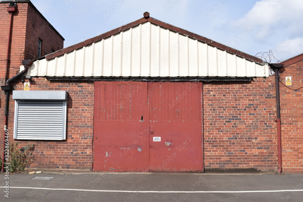 Gable Facade of Industrial Building with Closed Entrance Doors and Sealed Roller Shutter Window Gable Facade of Industrial Building with Closed Entrance Doors and Sealed Roller Shutter Window