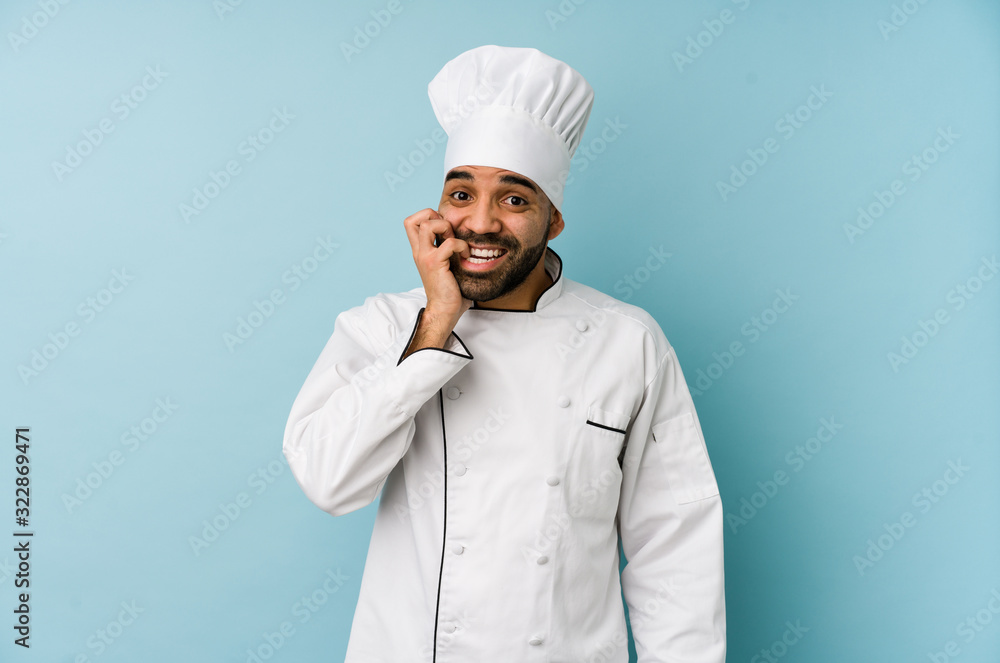 Young latin chef man isolated biting fingernails, nervous and very anxious. Young latin chef man isolated biting fingernails, nervous and very anxious.