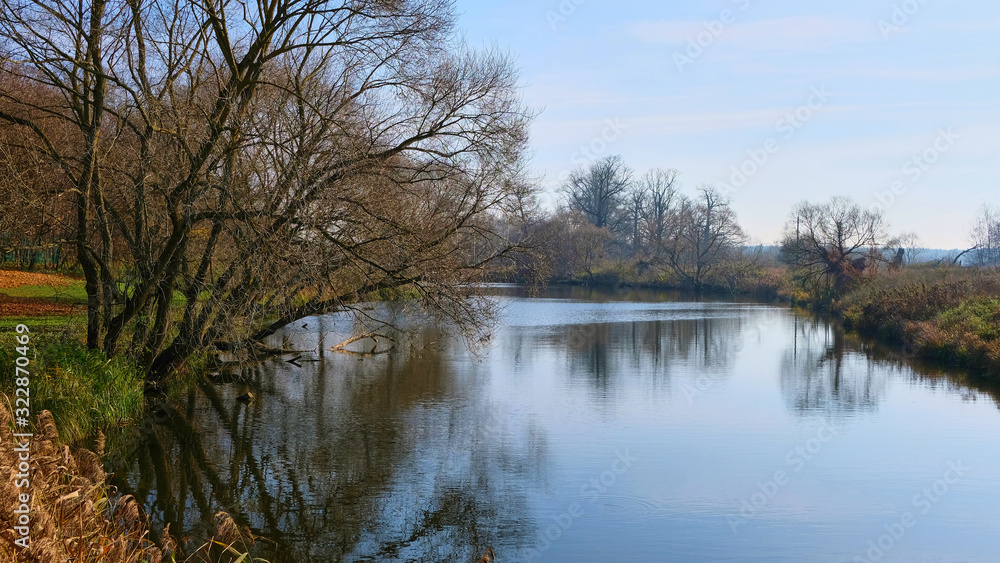 View of the river on the bank on a background of wood