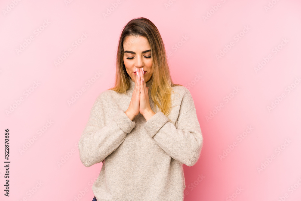 Middle age woman over isolated background holding hands in pray near mouth, feels confident. Middle age woman over isolated background holding hands in pray near mouth, feels confident.