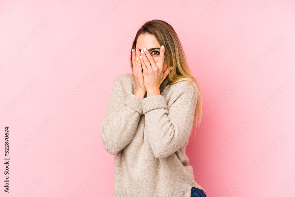 Middle age woman isolated on pink background blink through fingers frightened and nervous. Middle age woman isolated on pink background blink through fingers frightened and nervous.