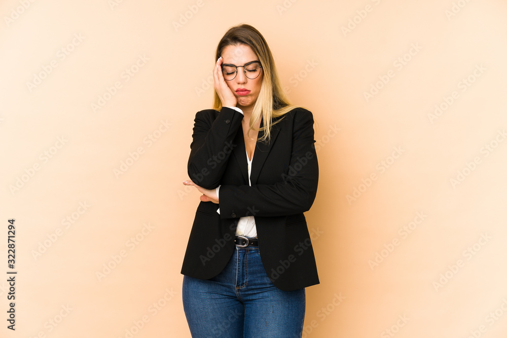 Middle age business woman isolated on beige background who is bored, fatigued and need a relax day. Middle age business woman isolated on beige background who is bored, fatigued and need a relax day.