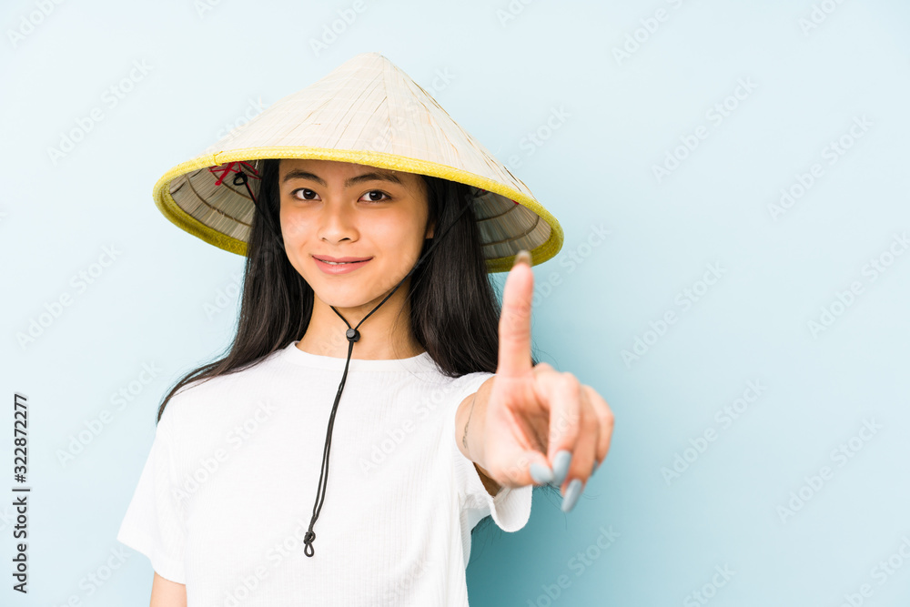 Young chinese woman wearing a vietnamese hay isolated happy, smiling and cheerful. Young chinese woman wearing a vietnamese hay isolated happy, smiling and cheerful.