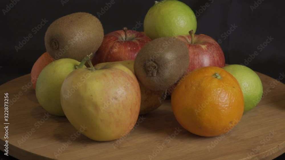 Fruta de colores girando en madera y findo negro Fruta de colores girando en madera y findo negro