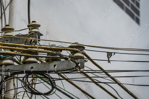 Densely wired telephone and electric cables outside residential buildings
