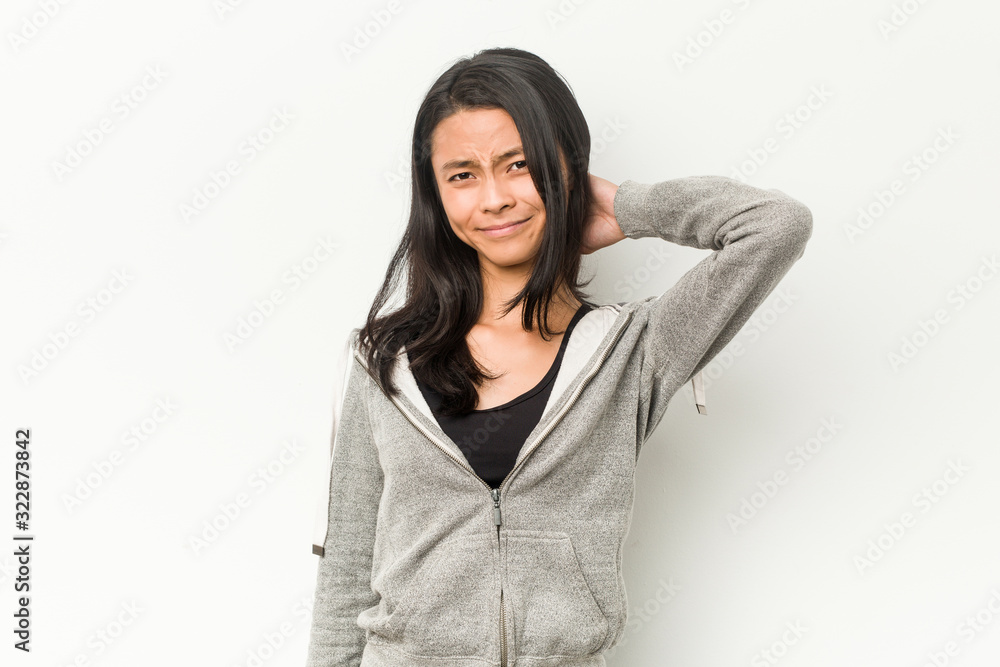 Young fitness chinese woman suffering neck pain due to sedentary lifestyle. Young fitness chinese woman suffering neck pain due to sedentary lifestyle.