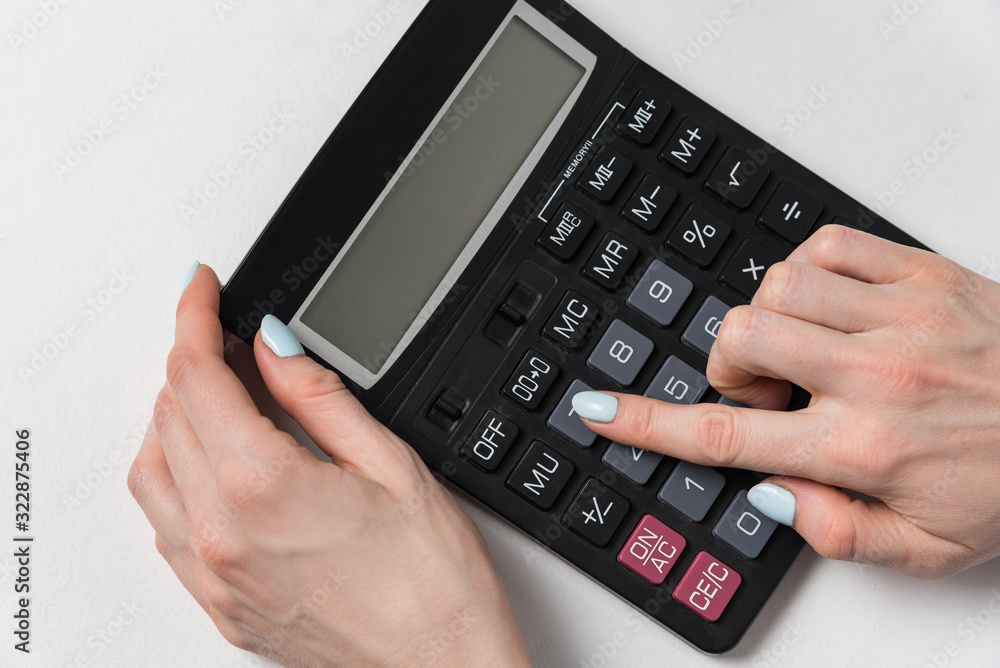 Women hand and calculator on a white background. Budget planning concept Women hand and calculator on a white background. Budget planning concept