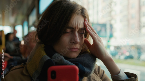 Woman use phone coughs into handkerchief sneezes on the tram look at camera cold autumn day flu season disease fever grippe health illness infection influenza migraine sickness slow motion