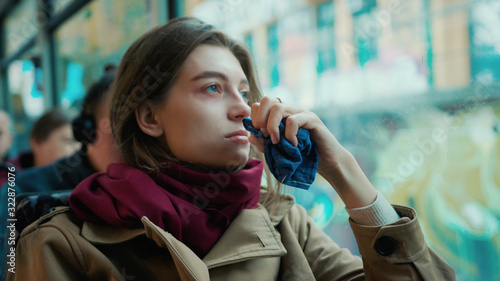 Portrait young attractive woman look on window on the tram on a cold autumn day at the start of the flu season disease fever flu grippe health illness infection influenza migraine sickness slow motion