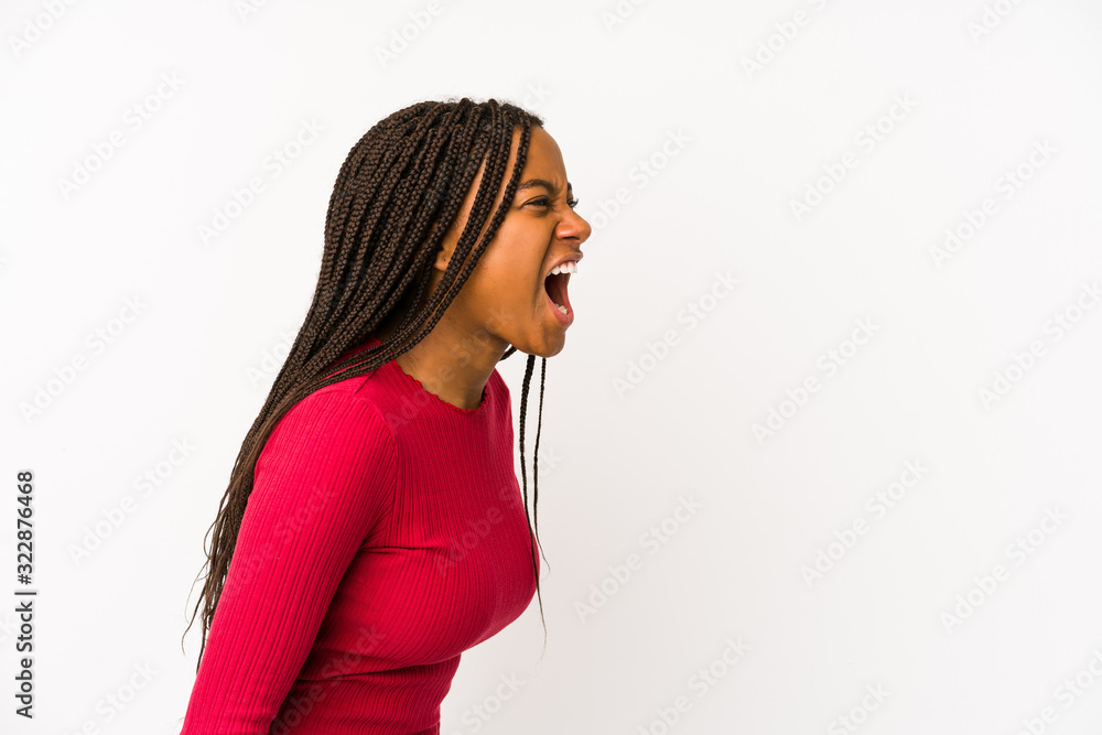 Young african american woman isolated shouting towards a copy space Young african american woman isolated shouting towards a copy space