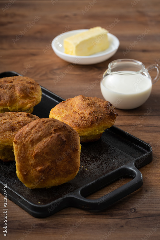 HANDCRAFTED CORN BREAD, ECUADORIAN KITCHEN RECIPE, SERVED ON WOODEN TABLE, WITH MILK AND BUTTER HANDCRAFTED CORN BREAD, ECUADORIAN KITCHEN RECIPE, SERVED ON WOODEN TABLE, WITH MILK AND BUTTER