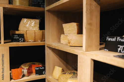 Shelf with cheese in cheese store. Assortment of different cheese types