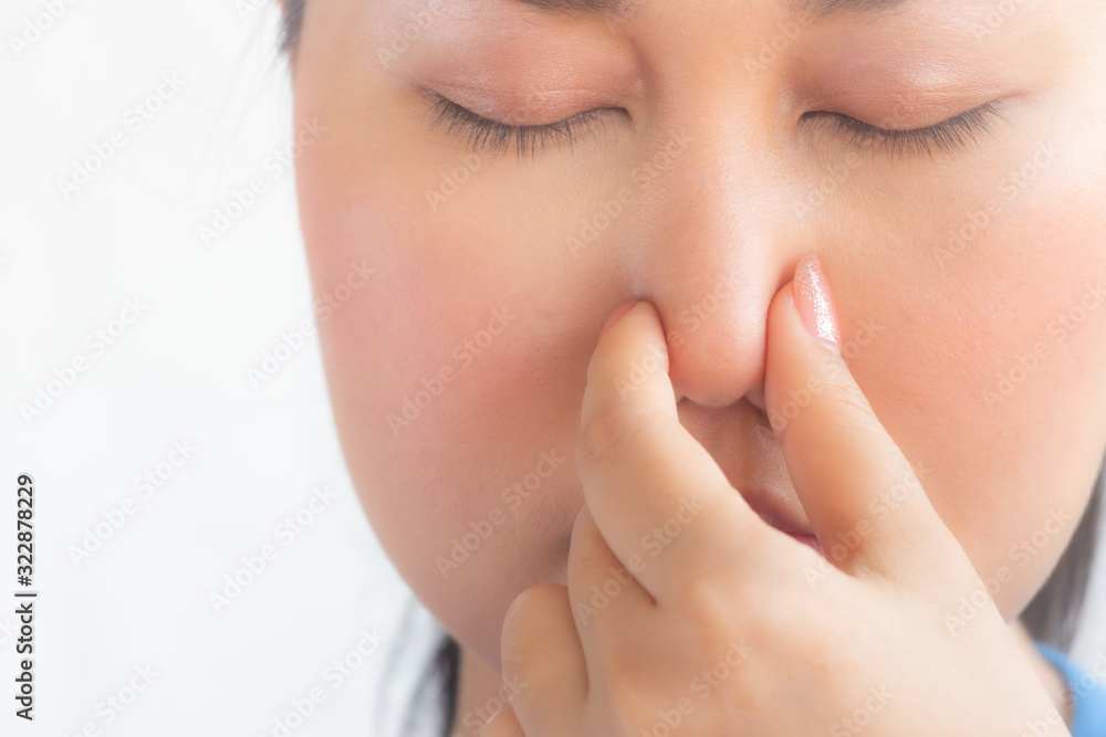 young pretty woman feeling disgusted, holding nose to avoid smelling a foul and unpleasant stench against white background,asian woman feel smell foul in white background. young pretty woman feeling disgusted, holding nose to avoid smelling a foul and unpleasant stench against white background,asian woman feel smell foul in white background.