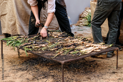 Man's hands picking spring onion fried on grill one Holiday of spring onion on the market.