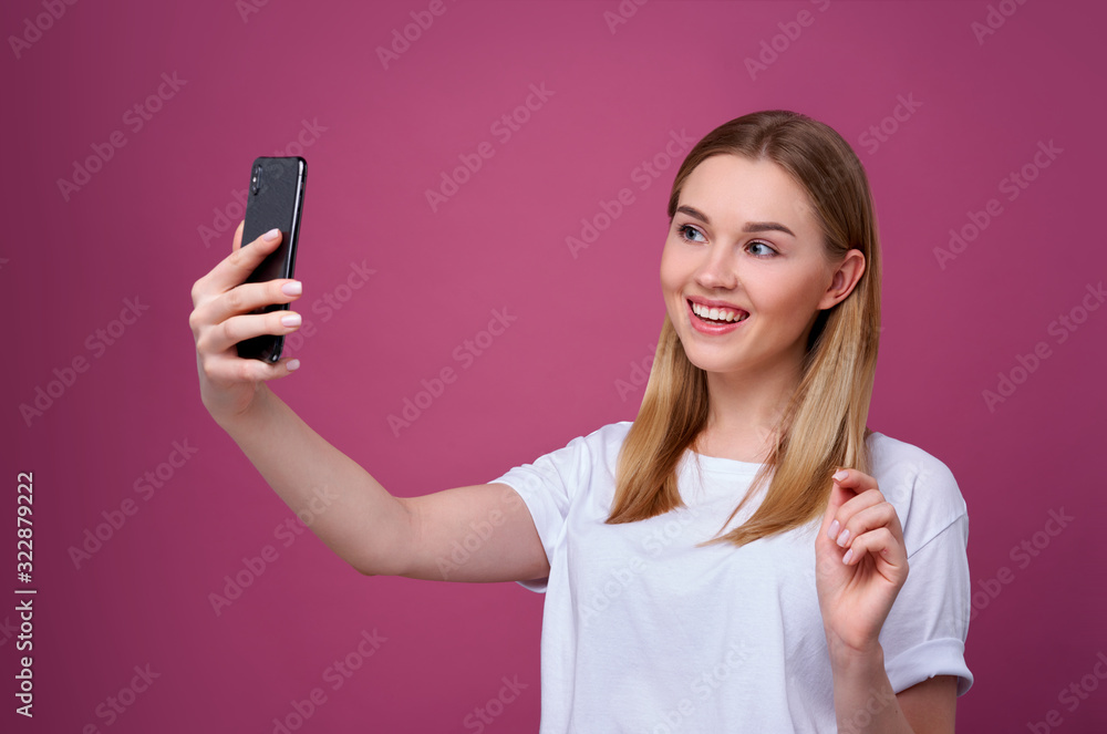 Portrait of a young attractive woman making selfie photo on smartphone isolated. Portrait of a young attractive woman making selfie photo on smartphone isolated.