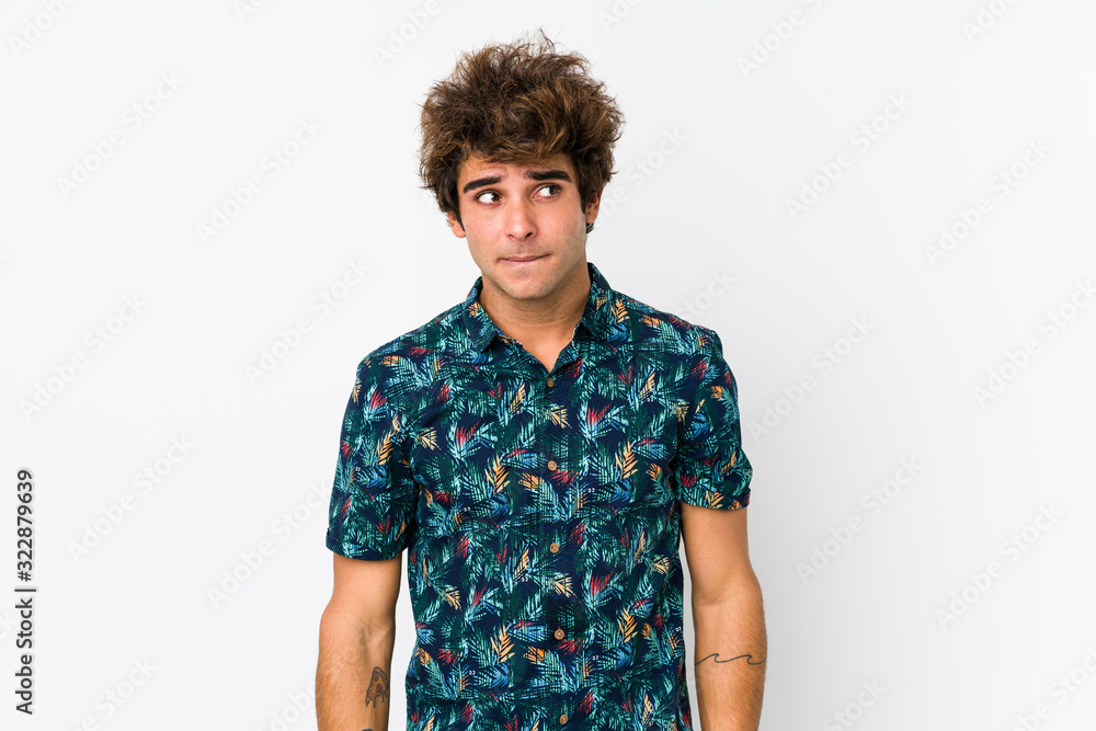 Young caucasian man wearing a flower t-shirt isolated confused, feels doubtful and unsure. Young caucasian man wearing a flower t-shirt isolated confused, feels doubtful and unsure.