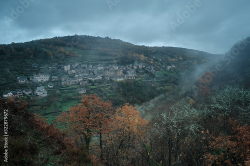 Fog over medieval village surrounded by forests