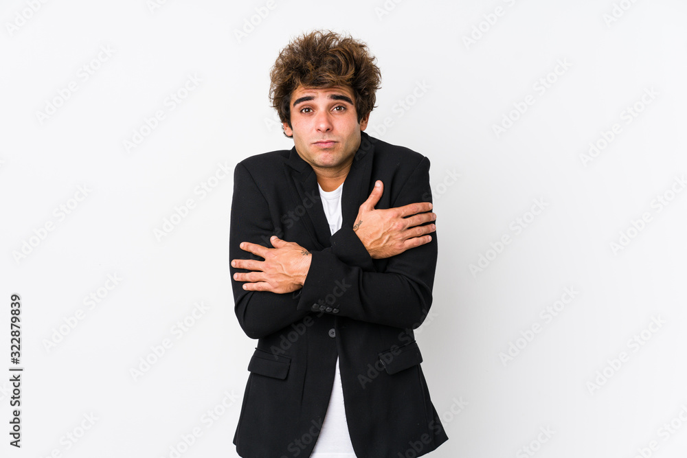 Young caucasian business man against a white background isolated going cold due to low temperature or a sickness.