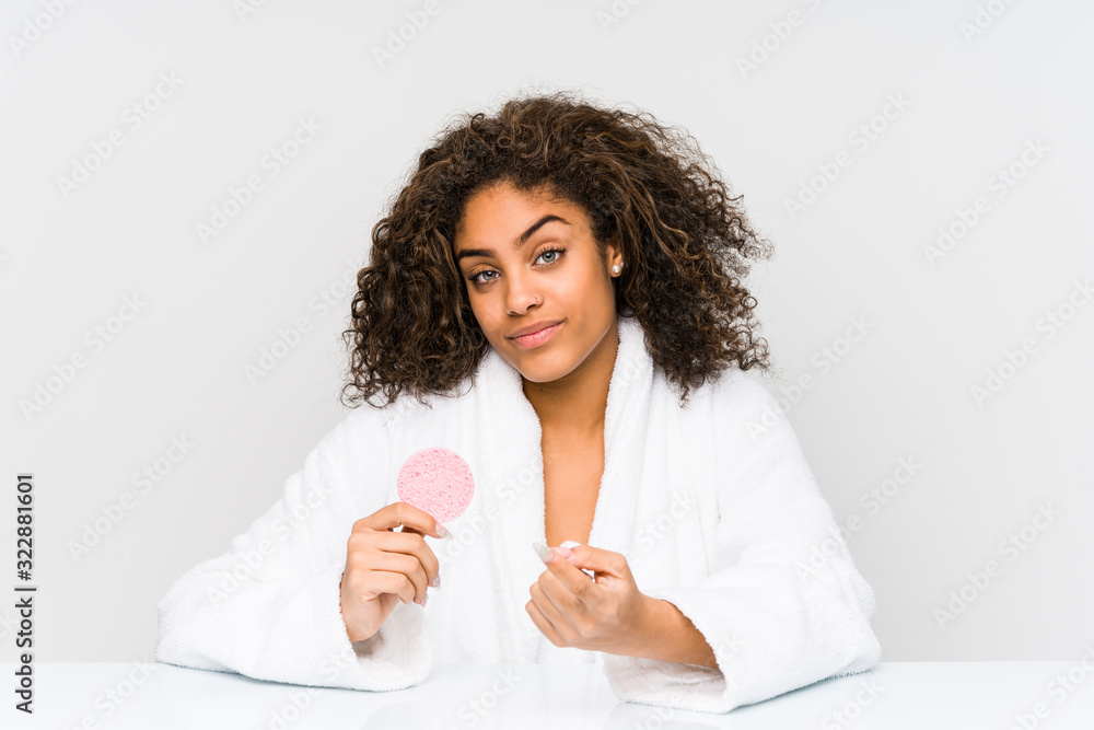 Young african american woman using a facial disk pointing with finger at you as if inviting come closer. Young african american woman using a facial disk pointing with finger at you as if inviting come closer.