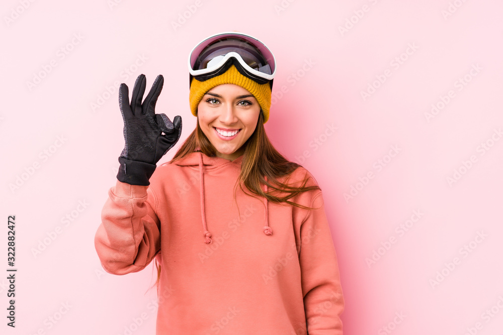 Fototapeta premium Young caucasian woman wearing a ski clothes isolated cheerful and confident showing ok gesture.
