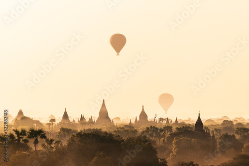 Scenic sunrise with many hot air balloons above Bagan in Myanmar. Bagan is an ancient city with thousands of historic buddhist temples and stupas.