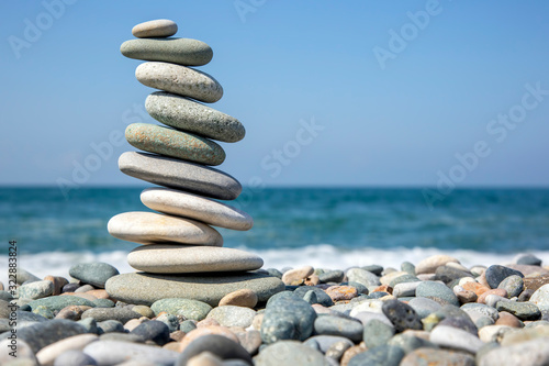 balance a pyramid of smooth stones on the background of the sea