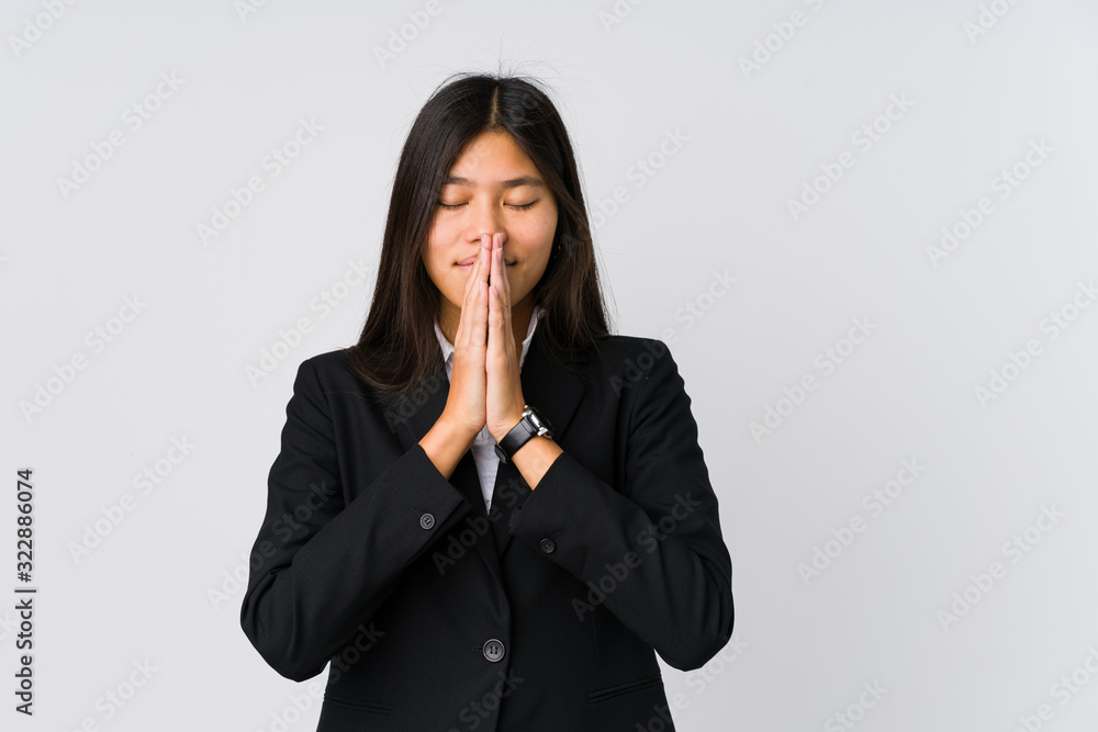 Young asian business woman holding hands in pray near mouth, feels confident. Young asian business woman holding hands in pray near mouth, feels confident.