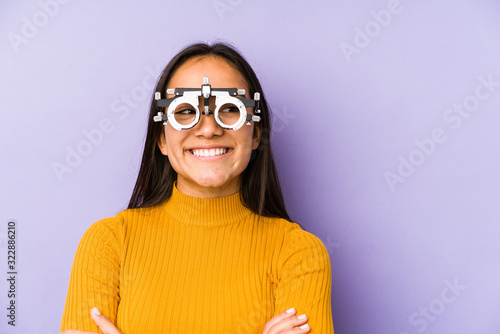 Youn indian woman with optometry glasses smiling confident with crossed arms.