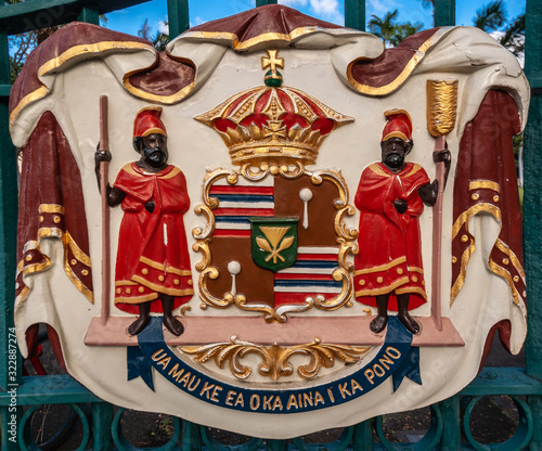 Honolulu  Oahu, Hawaii, USA. - January 10, 2012: Closeup of Hawaii Coat of Arms with State Motto is colorful shield with long text in Hawaiian, royal crown and 2 black skinned figures in red.