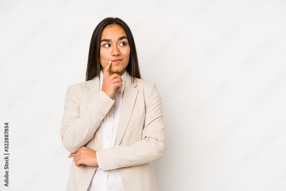 Young woman isolated on a white background looking sideways with doubtful and skeptical expression. Young woman isolated on a white background looking sideways with doubtful and skeptical expression.