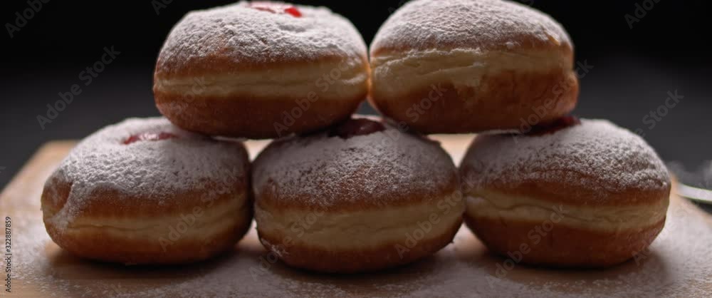 Close up of hanukkah doughnuts on a wooden board, slow motion, BMPCC 4K Close up of hanukkah doughnuts on a wooden board, slow motion, BMPCC 4K