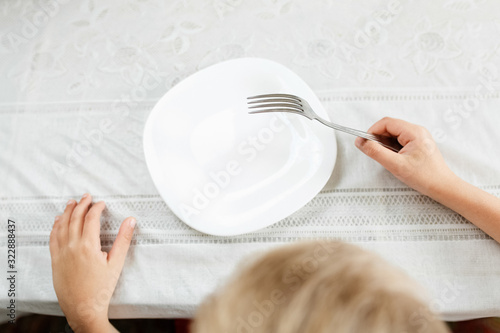 boy is looking at an empty plate