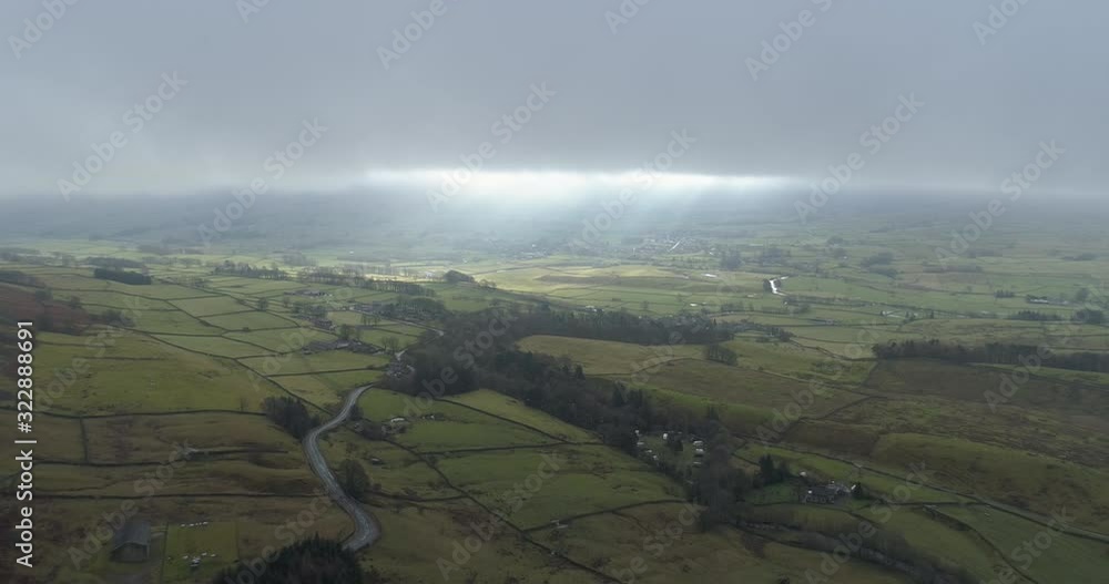 Aerial shot of sunlight breaking through the clouds over countryside in Wensleydale, North Yorkshire. Aerial shot of sunlight breaking through the clouds over countryside in Wensleydale, North Yorkshire.