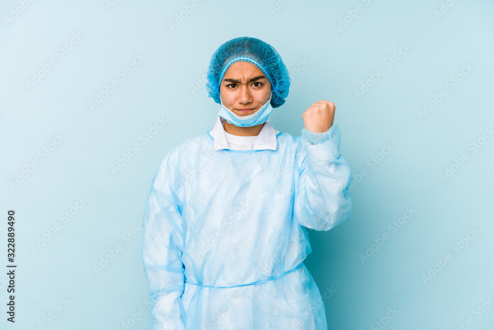 Young surgeon asian woman isolated showing fist to camera, aggressive facial expression. Young surgeon asian woman isolated showing fist to camera, aggressive facial expression.