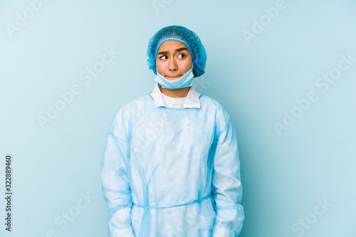 Young surgeon asian woman isolated confused, feels doubtful and unsure. © Asier