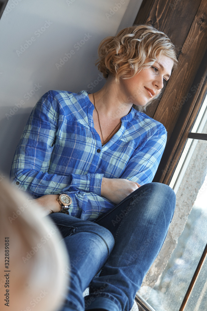 beautiful woman seats in front of the window beautiful woman seats in front of the window