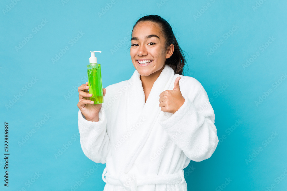 Young mixed race indian holding an aloe vera bottle smiling and raising thumb up Young mixed race indian holding an aloe vera bottle smiling and raising thumb up