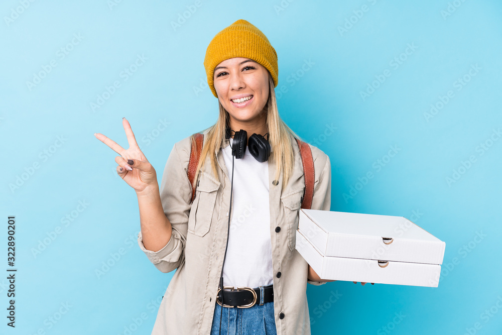 Young caucasian woman holding pizzas isolated joyful and carefree showing a peace symbol with fingers. Young caucasian woman holding pizzas isolated joyful and carefree showing a peace symbol with fingers.
