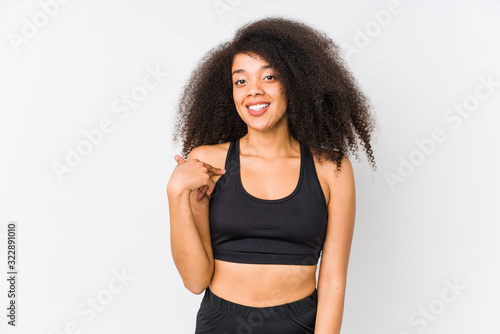 Young african american sporty woman person pointing by hand to a shirt copy space, proud and confident